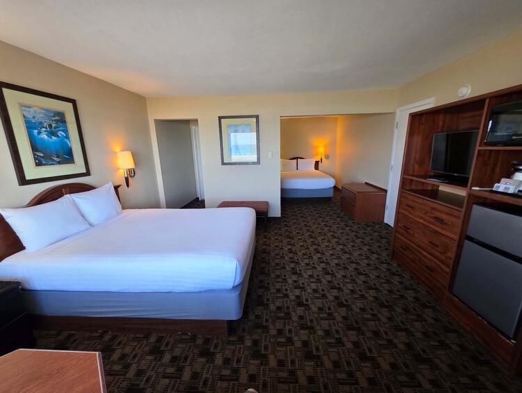 Two Queen guest room with two beds, a TV, and mini-fridge