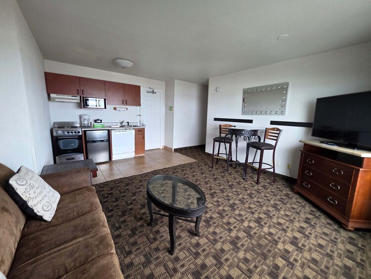 Executive Suite living room with a seating area and TV next to the kitchen