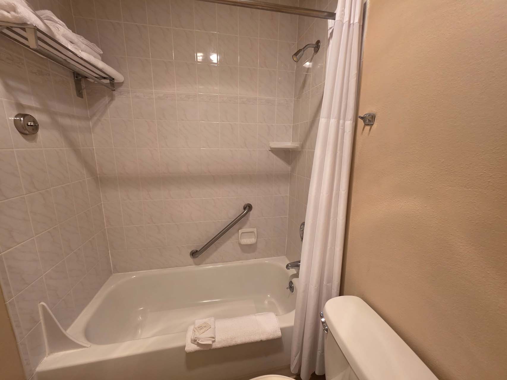Guest bathroom with a tub and shower combination with grab bars
