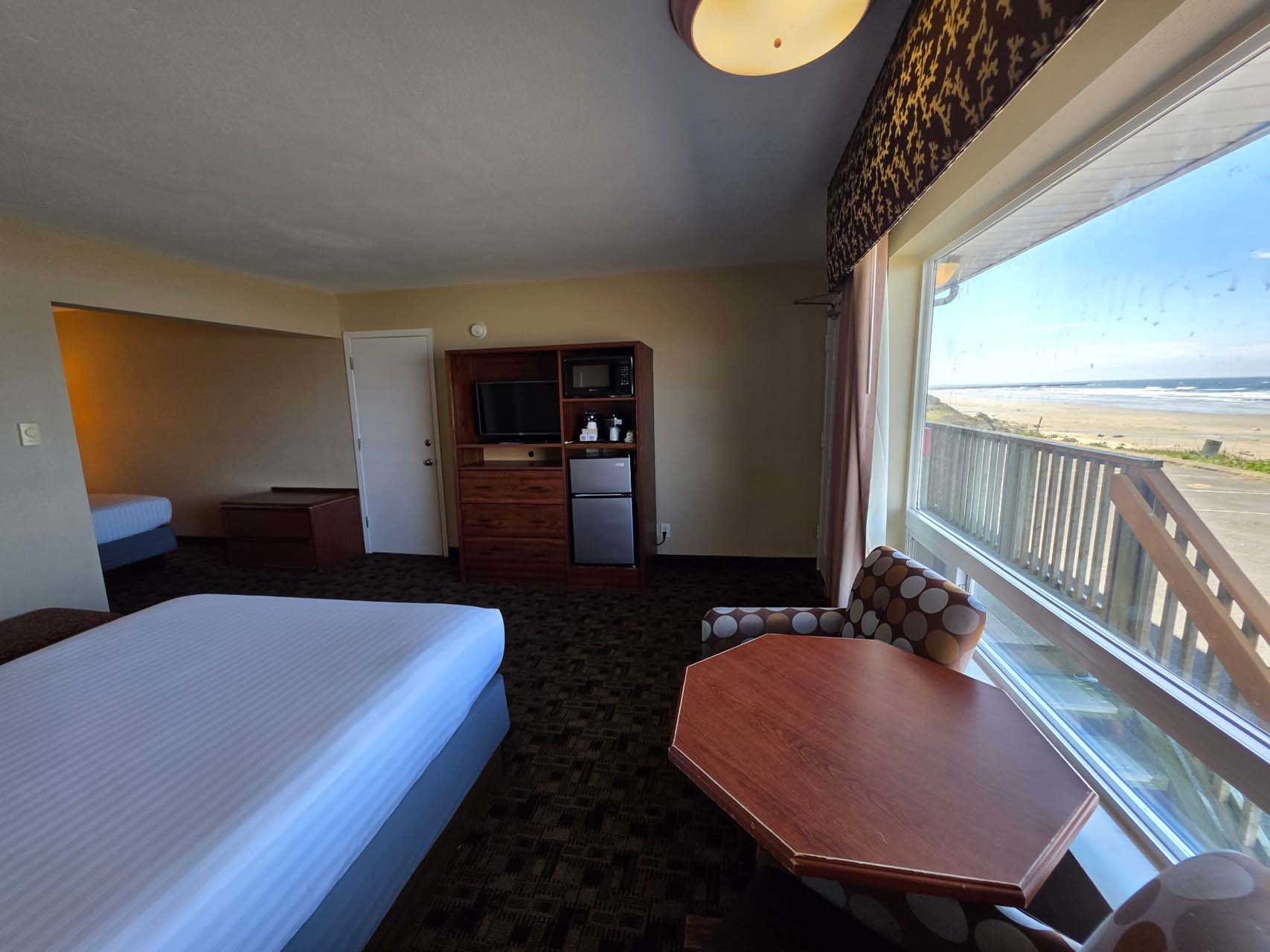 Two Queen guest room with a large window, a table, a TV, and mini-fridge