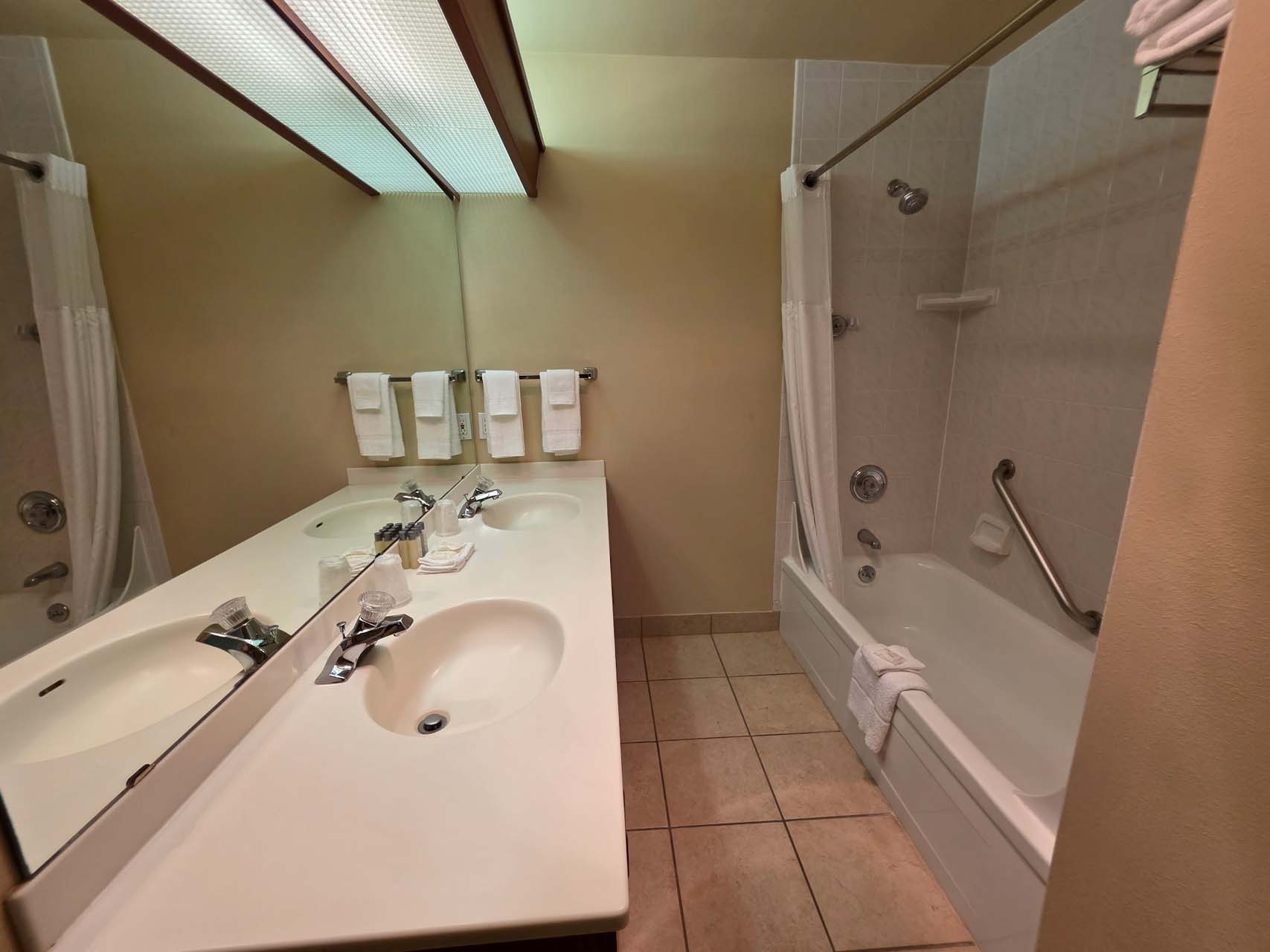 Guest bathroom with a double sink and a shower and tub combination