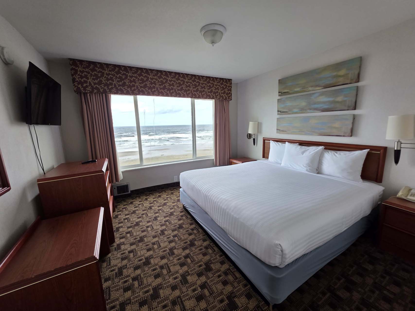 King room with a king bed, a TV, and a large window