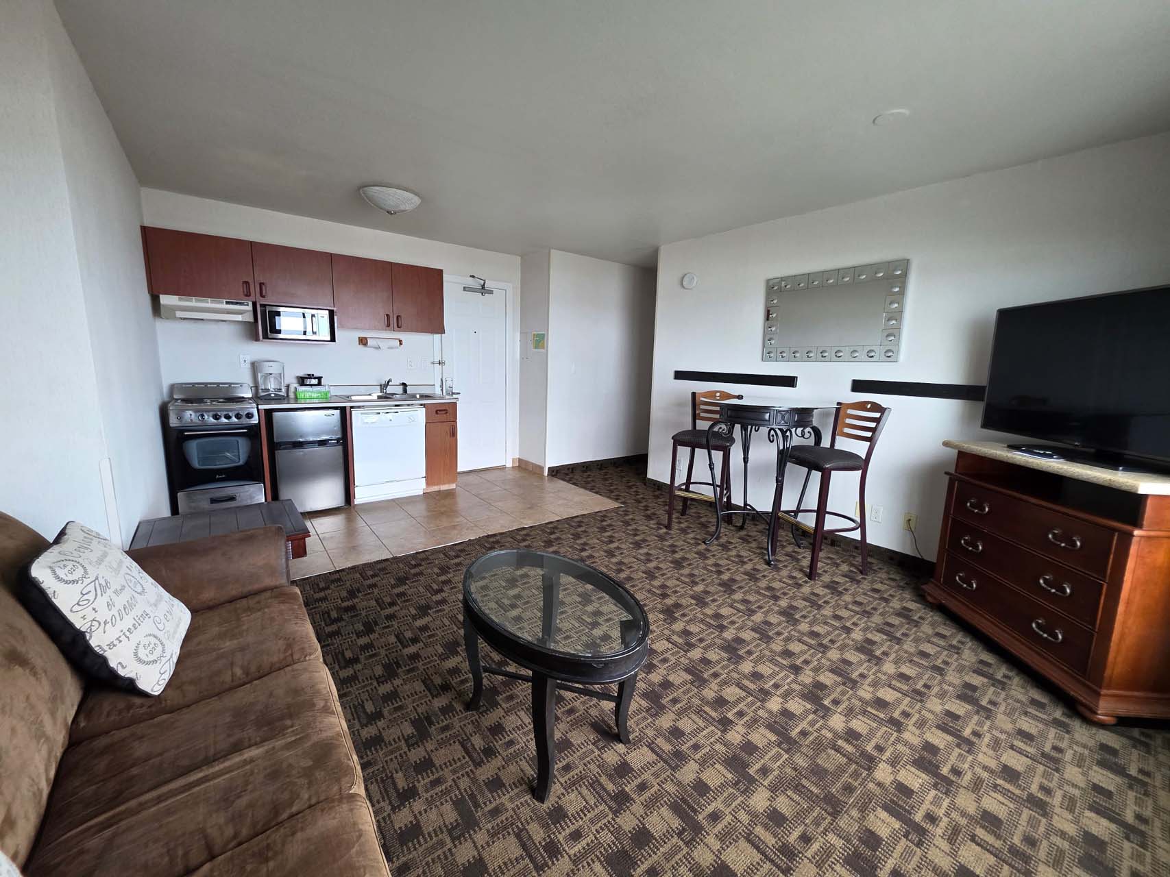 Executive Suite living room with a seating area and TV next to the kitchen