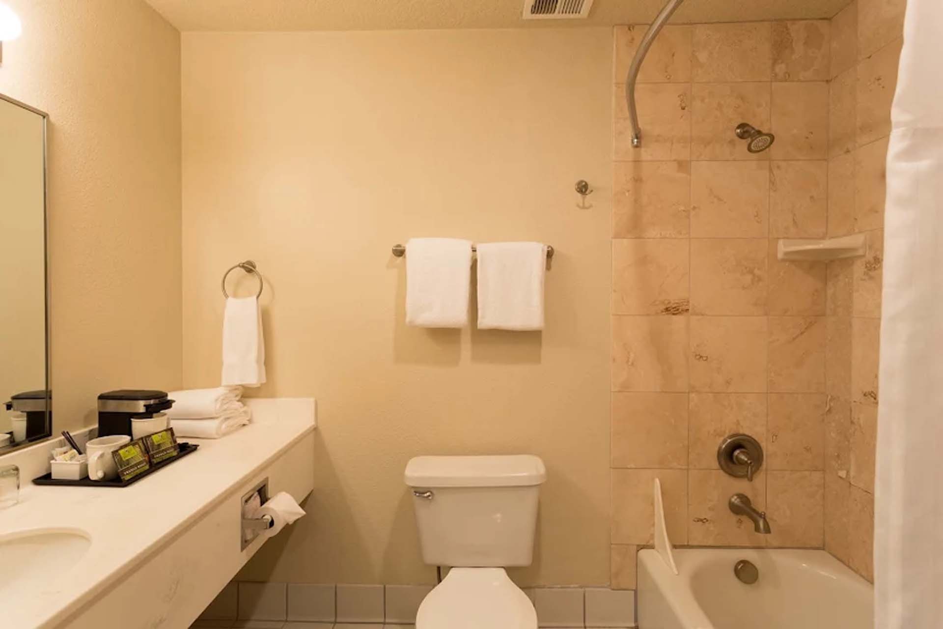 Guest bathroom with one sink, a toilet, and a shower and tub combination