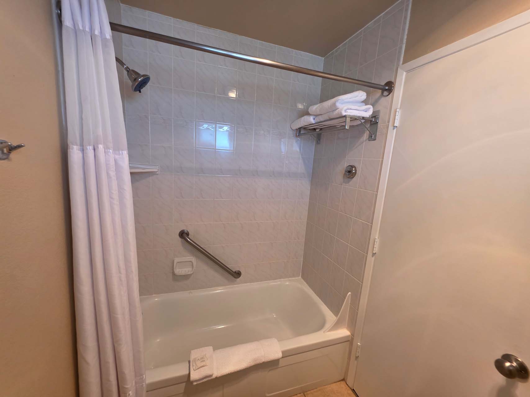 Guest bathroom with a shower and tub combination with grab bars