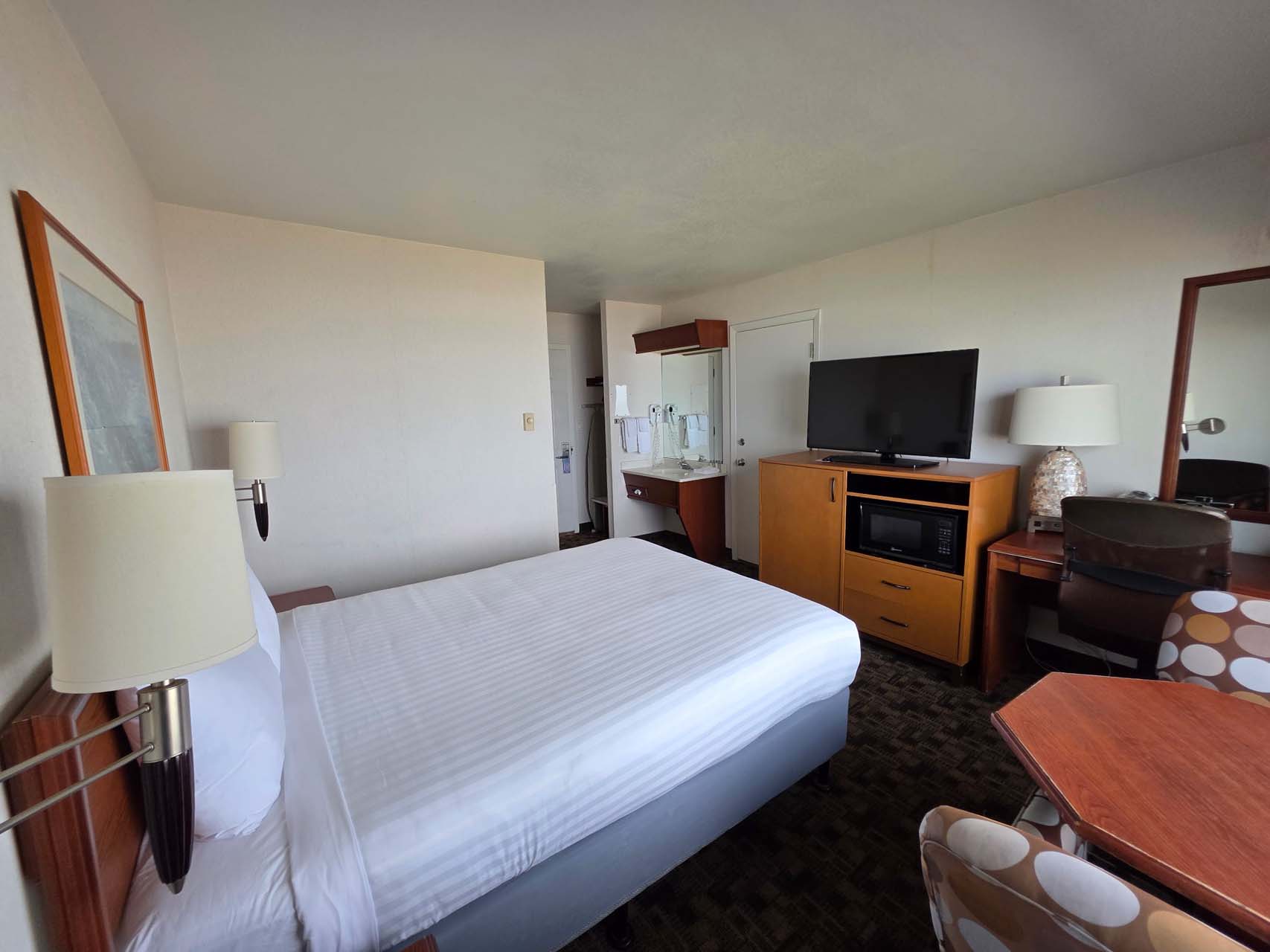 Guest room with one queen bed, a TV, and a nightstand